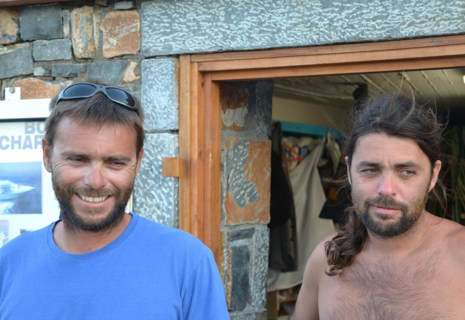 Working portrait of Tolis and Alex Evangelou, father and son, at the Mare watersports station — two generations of the same role across more than four decades.